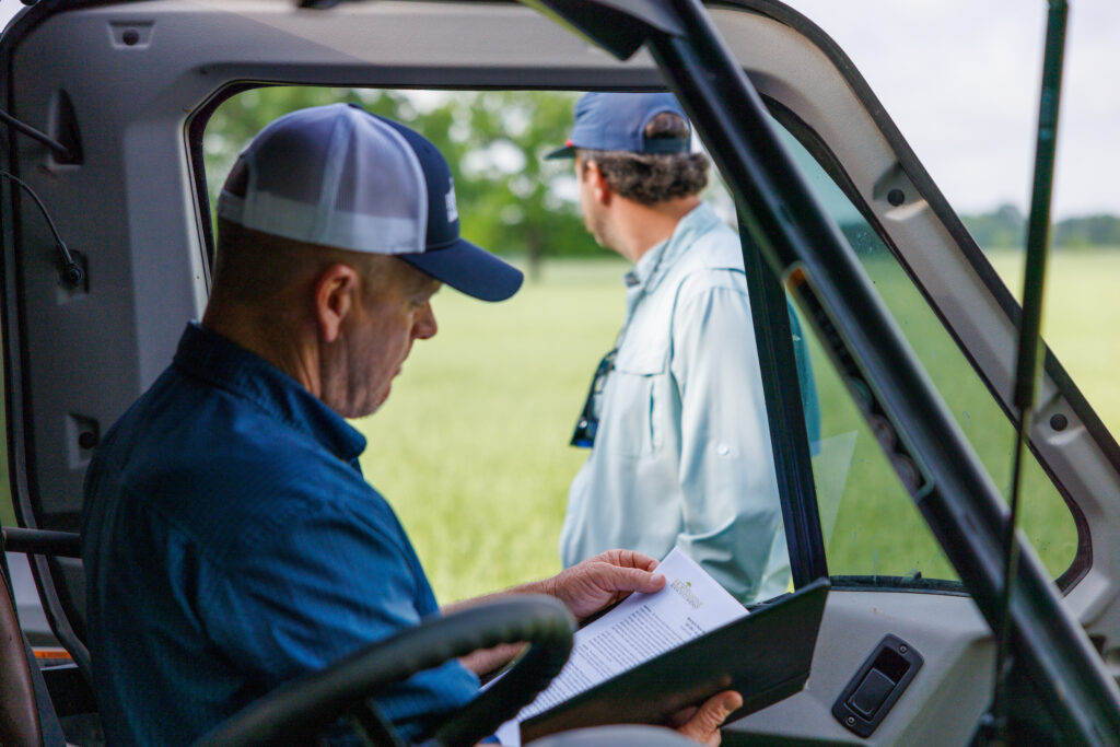 Hortenstine Ranch Company broker reviewing ranch details with a client in the field